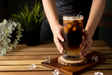 Glass of espresso with lemon juice on wooden table and copy space, Summer Cocktail, Cold brew coffee or black tea. (close up, selective focus), Pouring cold drink.