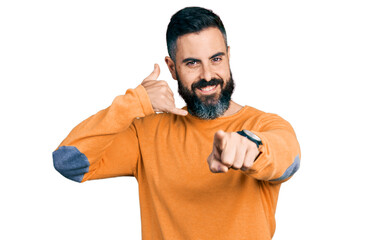 Hispanic man with beard wearing casual winter sweater smiling doing talking on the telephone...