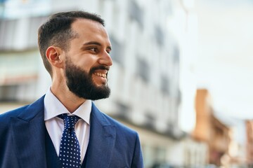 Naklejka premium Young businessman smiling happy standing at the city.