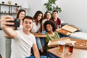 Group of young friends eating italian pizza make selfie by the smartphone at home.