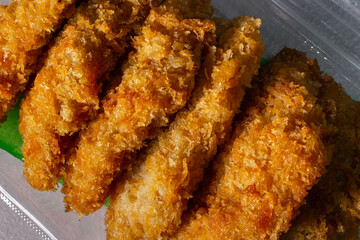 A pack of Japanese fried chicken tenders on the table. Takeout fast-food concept image.