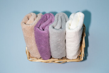 Fototapeta na wymiar Bath towels in basket on blue background. top view, copy space