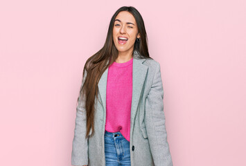 Young hispanic girl wearing business clothes winking looking at the camera with sexy expression,...