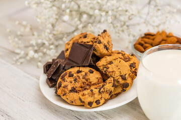 Chocolate cookies on white wooden table with milk. Chocolate chip cookies shot