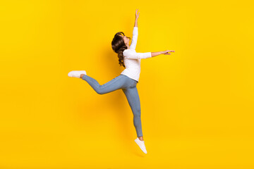 Photo of adorable shiny woman wear white shirt jumping high dancing isolated yellow color background