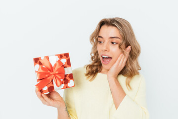 Surprised happy blonde girl holding a red gift box