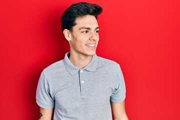 Young hispanic man wearing casual clothes looking to side, relax profile pose with natural face and confident smile.