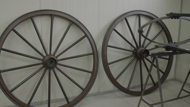 Large old carriage wheels standing in a modern workshop