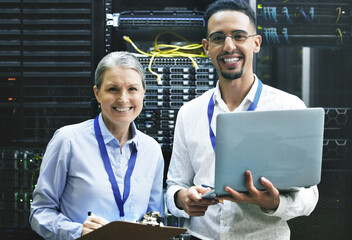 Teamwork makes technology work. Shot of two technicians working together in a server room.