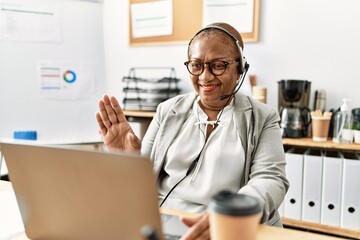 Senior african american woman call center agent having video call at office