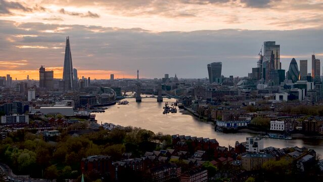 Wide, panoramic day to night time lapse view of the modern cityscape of London, England, with street and river traffic