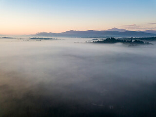 Sunrise over the fog in the Ukrainian Carpathians. Aerial drone view.