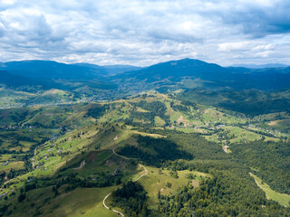 Obraz premium Green mountains of Ukrainian Carpathians in summer. Coniferous trees on the slopes. Aerial drone view.