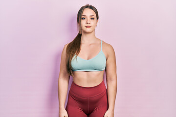 Young hispanic girl wearing sportswear relaxed with serious expression on face. simple and natural looking at the camera.