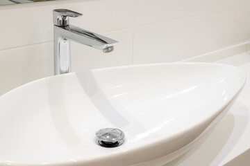 Fototapeta premium Modern white bathroom sink with faucet