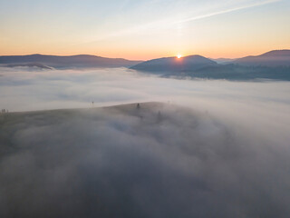 Sunrise over the fog in the Ukrainian Carpathians. Aerial drone view.