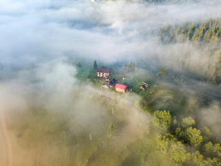 Fototapeta premium Mountain settlement in the Ukrainian Carpathians in the morning mist. Aerial drone view.