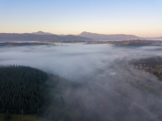 Fototapeta premium Sunrise over the fog in the Ukrainian Carpathians. Aerial drone view.