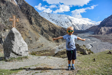 Naklejka premium A small boy near the Holy cross in the Daryal gorge, Kazbegi district, Mtskheta-Mtianeti region, Georgia. Georgia.