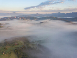 Green mountains of the Ukrainian Carpathians in the morning mist. Aerial drone view.