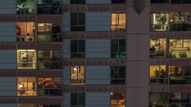 Windows in recidential building exterior in the late night with interior lights on timelapse