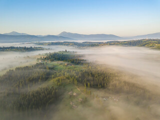 Morning mist in Ukrainian Carpathian mountains. Aerial drone view.