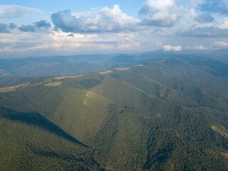 Obraz premium Green slopes of Ukrainian Carpathian mountains in summer. Cloudy day, low clouds. Aerial drone view.