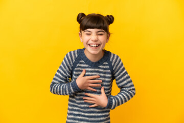 Little caucasian girl isolated on yellow background smiling a lot