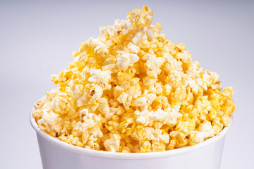Popcorn in white paper bucket, Close up Popcorn on white cardboard.