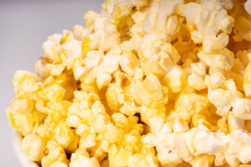 Popcorn in white paper bucket, Close up Popcorn on white cardboard.