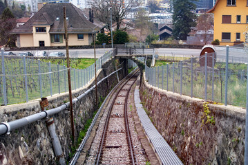 Route with railway tracks of Funicular Vevey-Mont-Pèlerin on a cloudy spring day. Photo taken April 4th, 2022, Vevey, Switzerland.