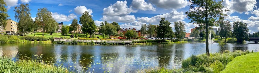 Obraz premium Panorama of a lake and green trees in summer, in Sweden