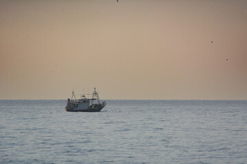 Nice little fishing boat on the Mediterranean sea at sunset
