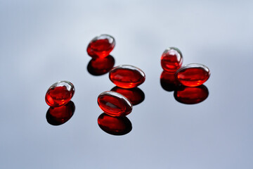 Krill oil pills on a glossy background