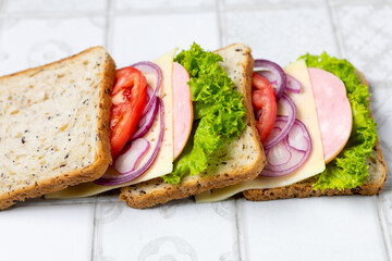 sandwich with ham cheese tomatoes lettuce onions. Ingredients for a sandwich with whole grain bread