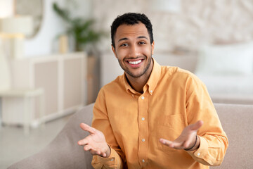 Smiling young man talking and gesturing to camera