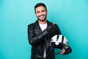 Young Brazilian woman with a motorcycle helmet isolated on blue background pointing to the side to present a product - obrazy, fototapety, plakaty