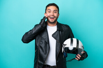 Young Brazilian woman with a motorcycle helmet isolated on blue background with surprise and...