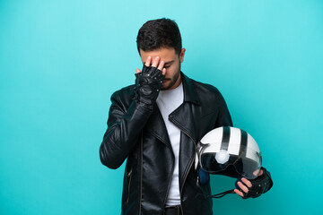 Young Brazilian woman with a motorcycle helmet isolated on blue background with tired and sick expression