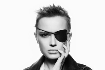 beautiful woman with eye patch and short hair. black and white portrait