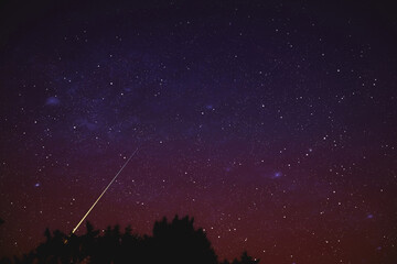 Stars, meteor trail on evening sky.