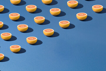 Pattern made of fresh grapefruit sliced in half.Royal blue background.Minimal creative style.