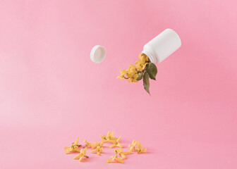 Yellow flowers come out of the plastic container bottle against pink pastel color.Creative summer of spring concept.