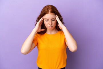 Teenager redhead girl over isolated purple background with headache