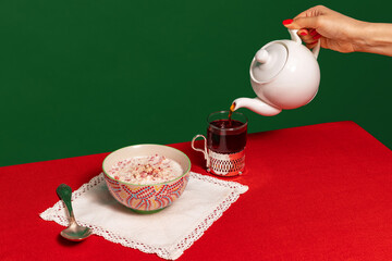 Served breakfast table. Food pop art photography. Tea pot, grapefruit and porridge on red...