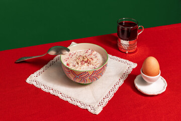 Served breakfast table. Food pop art photography. Tea pot, grapefruit and porridge on red tablecloth over green background. Vintage, retro style interior
