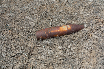 Rusty military bomb shell in the ground