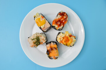 Japanese seafood sushi set on a white plate. Maki and rolls with tuna, salmon, shrimp, crab and avocado.