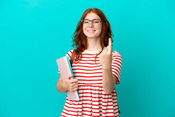 Student teenager redhead girl isolated on blue background doing coming gesture