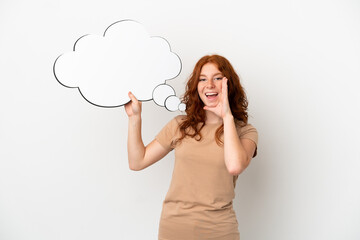 Teenager redhead girl isolated on white background holding a thinking speech bubble and shouting